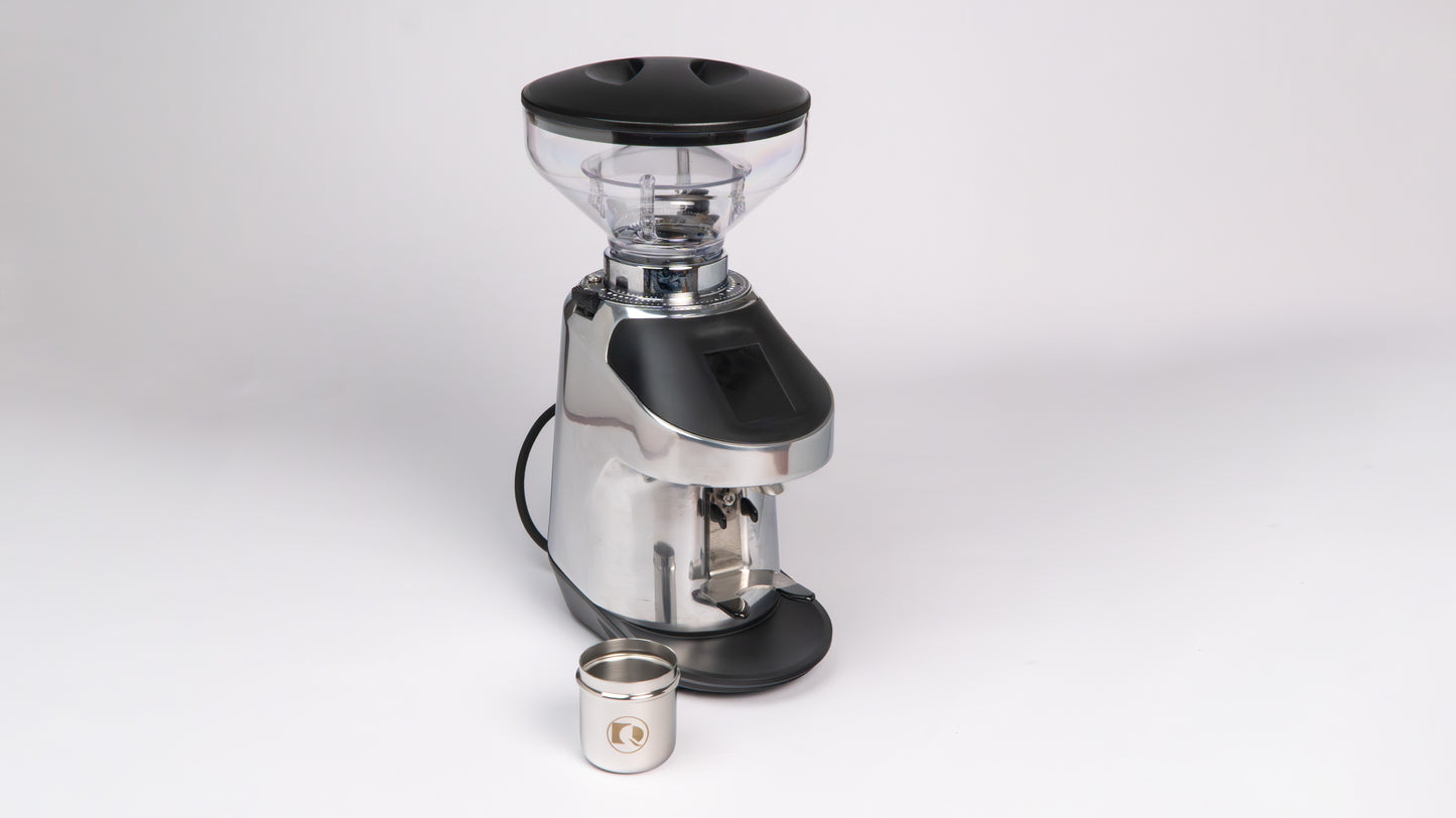 Quamar Nemo QE Black Coffee Grinder displayed with a metal container for ground coffee.