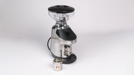 Quamar Nemo QE Black Coffee Grinder displayed with a metal container for ground coffee.
