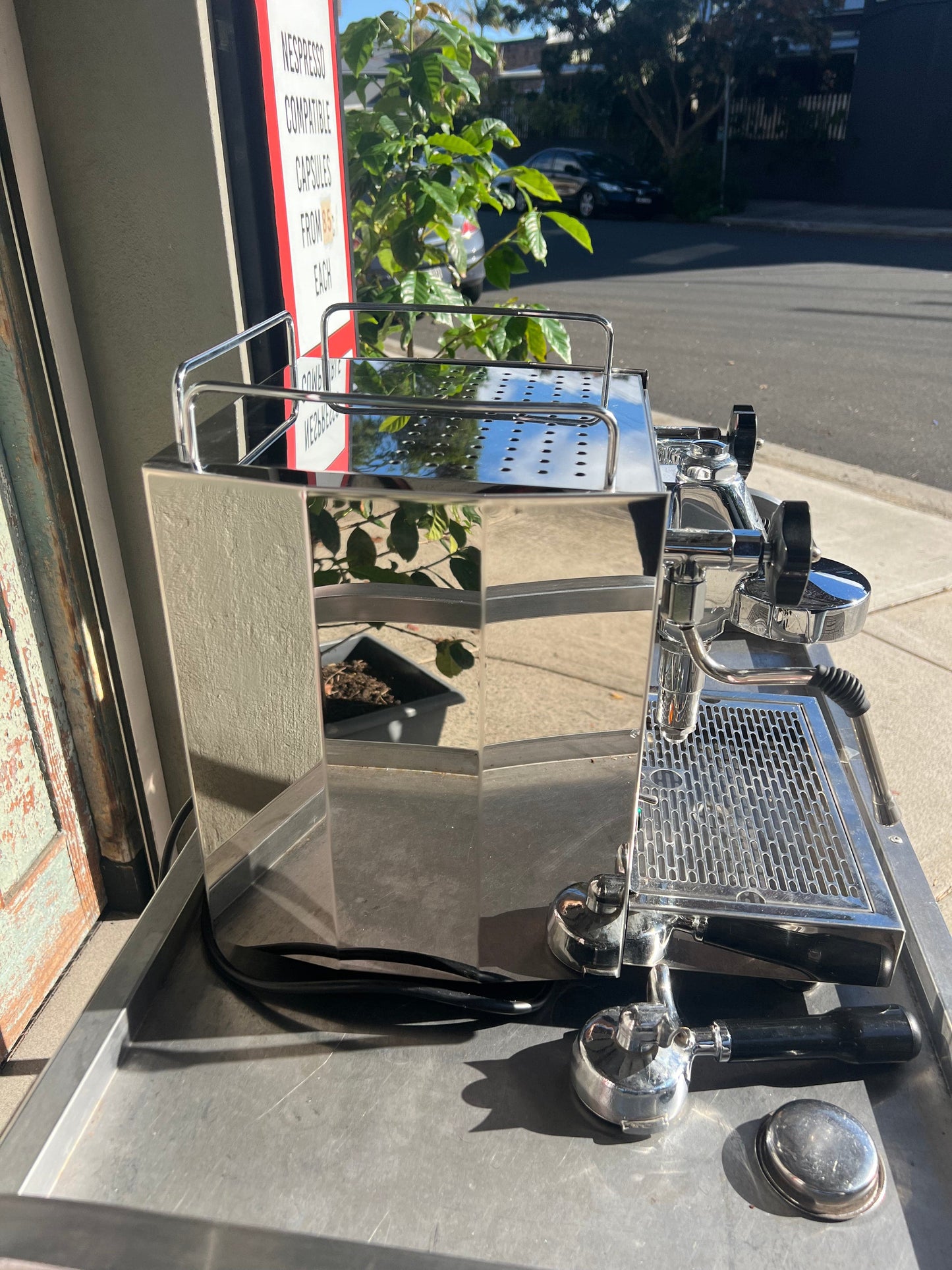 ECM Barista Coffee Machine displayed outdoors with polished chrome finish and accessories.