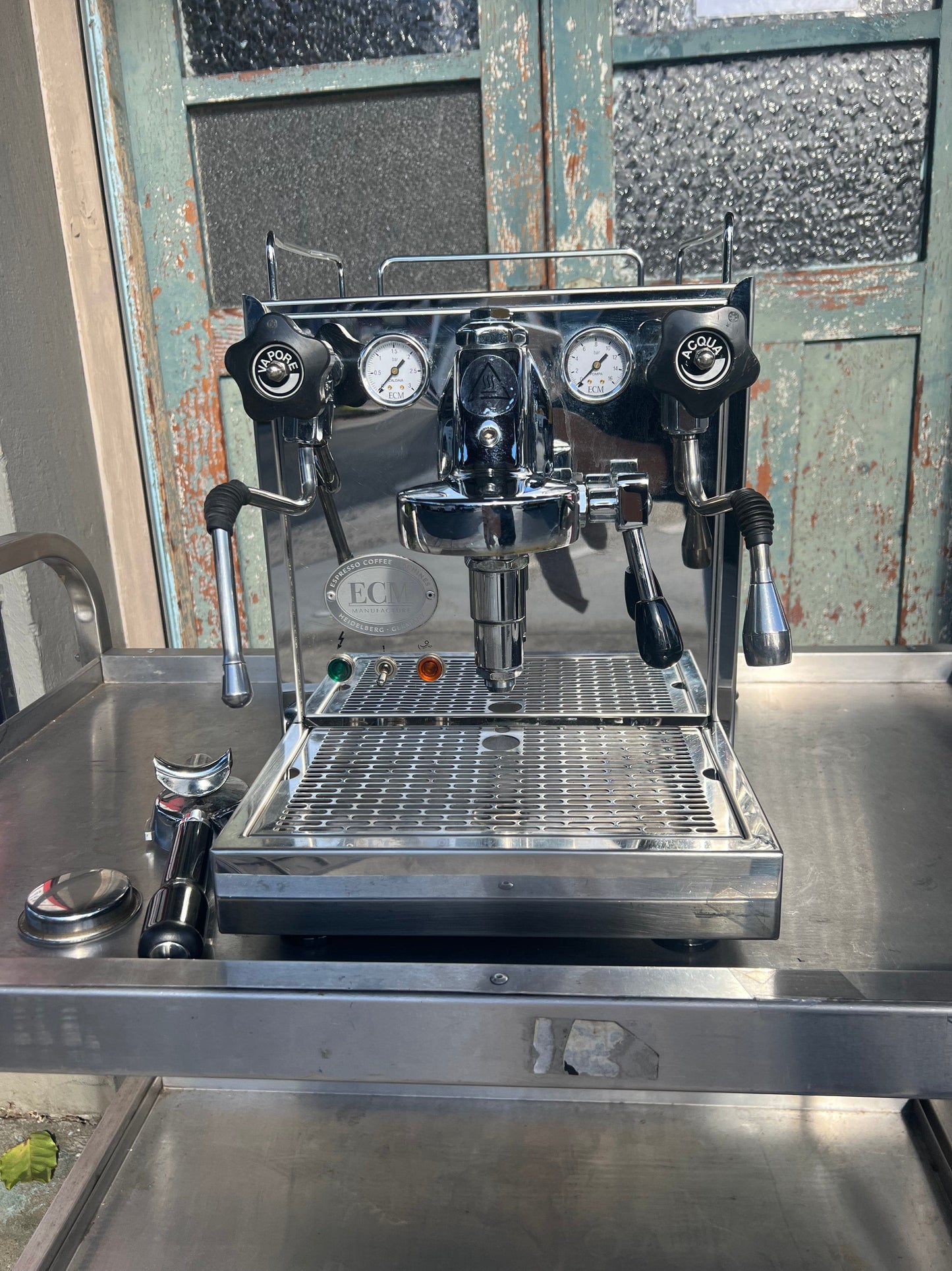 ECM Barista Coffee Machine with chrome finish and pressure gauges on a stainless steel countertop.