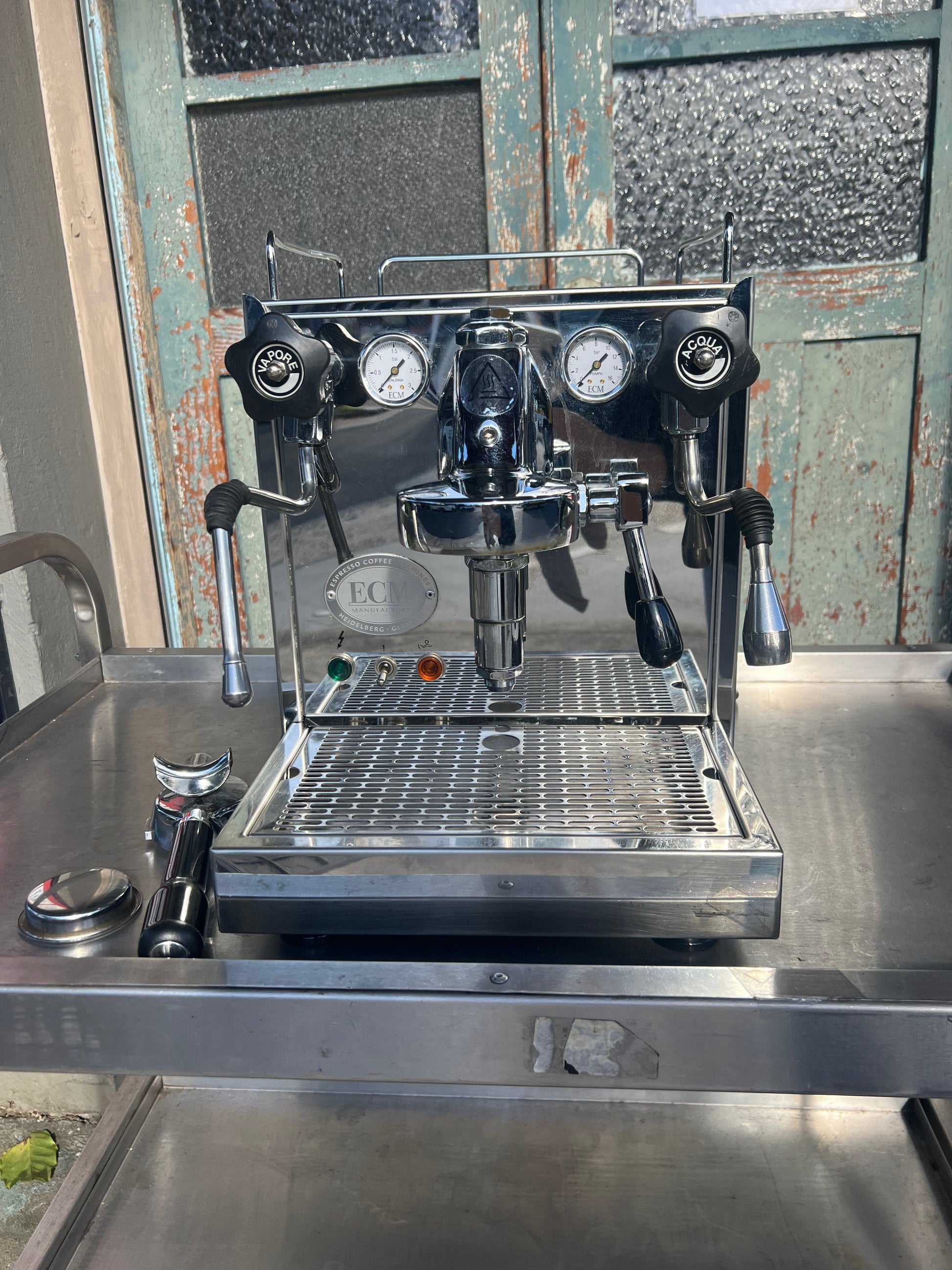 ECM Barista Coffee Machine with chrome finish and pressure gauges on a stainless steel countertop.